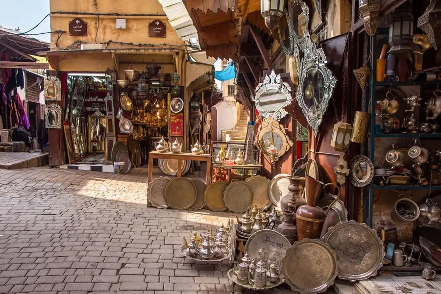 Brass and copper trays, teapots and lanterns at a shop in the Fes medina